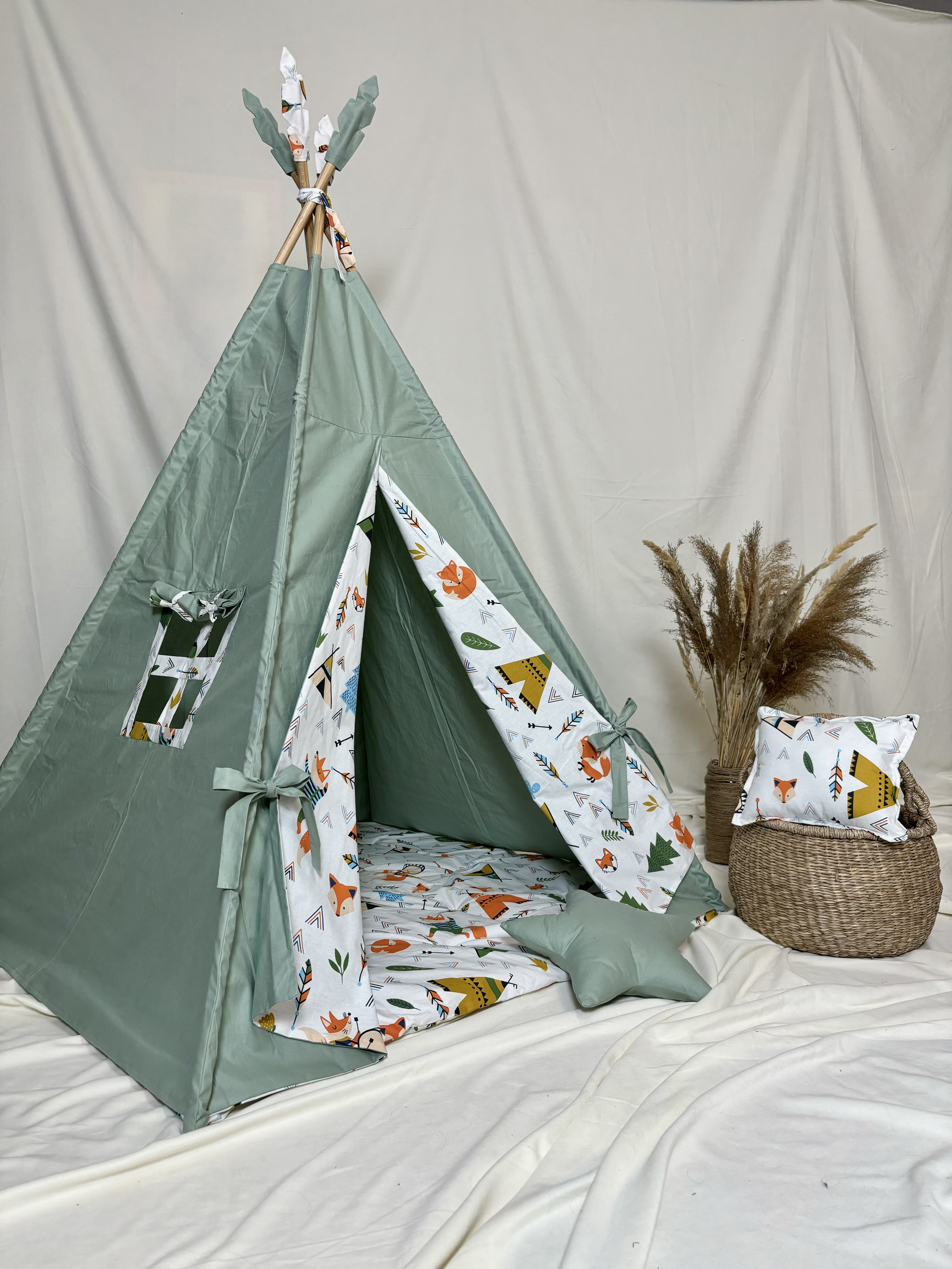 Green tent with star and square shaped pillows