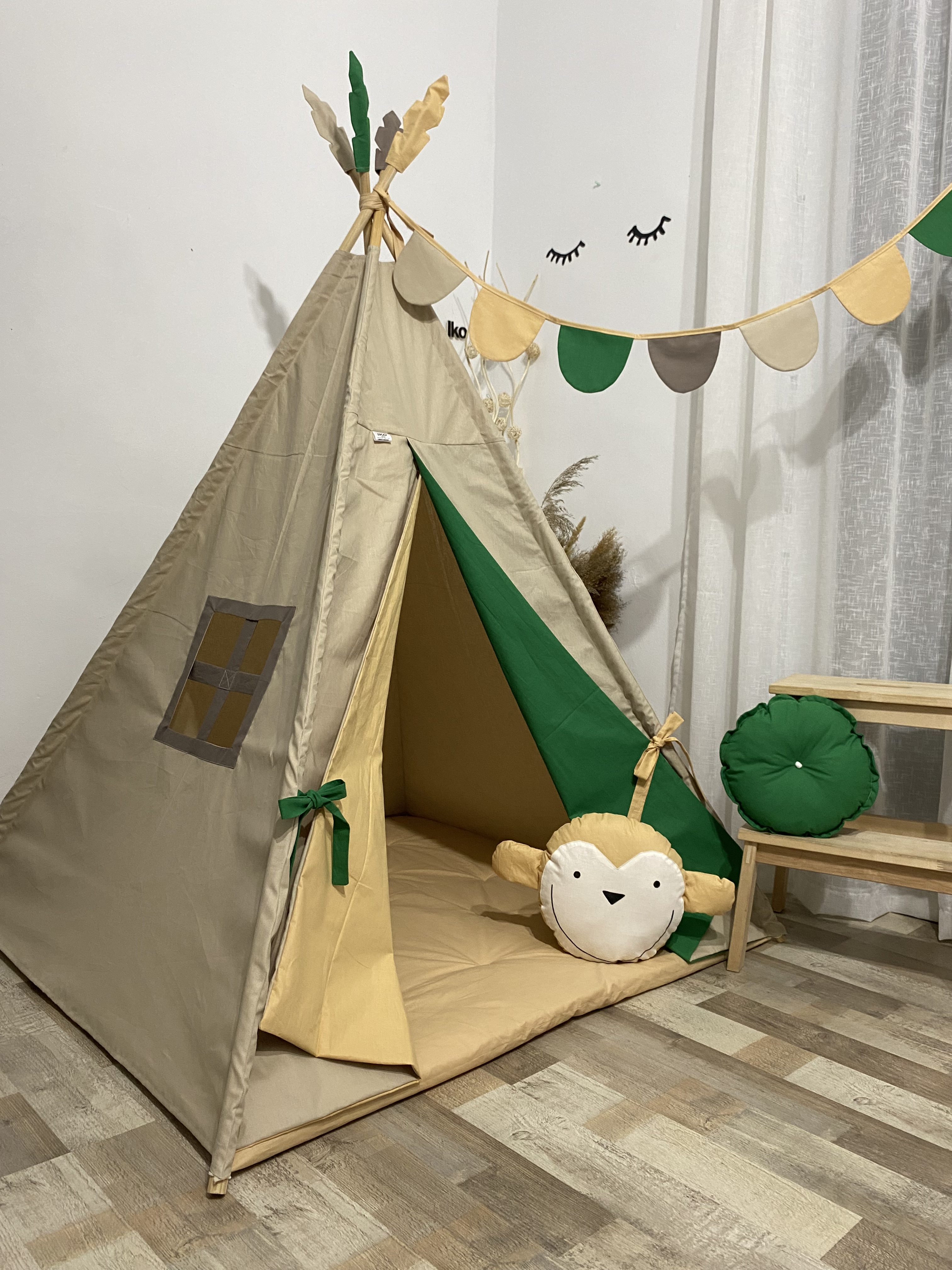 Kds' tent with colorful skirts and a pillow with a monkey, pillow with monkey and hanging flags